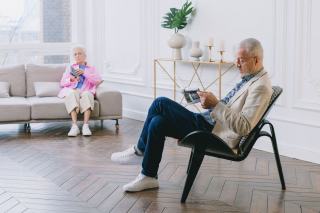 Grands-parents ouvrant un coffret cadeau dans leur salon
